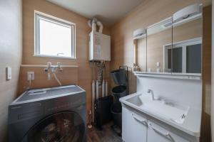 a bathroom with a washing machine and a sink at ZABOCON Honcho Terrace in Sapporo
