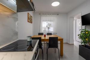 a kitchen and dining room with a wooden table and chairs at Apartments Sidro in Savudrija