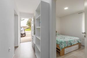 a bedroom with a bed and a door to a driveway at Apartments Sidro in Savudrija