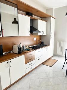 a kitchen with white cabinets and a counter top at TERRA DI SUD Matera - Free secure parking in Matera