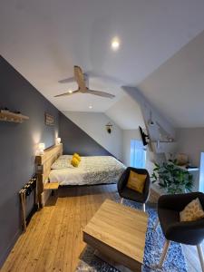 a bedroom with a bed and two chairs in a attic at Au fil de l’Ô in Bisseuil +65 photos