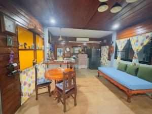 a living room with a table and a blue couch at โฮมสเตย์ริมน้ำน่าน บ้านอิ๊กขะหลิ๊ก in Nan