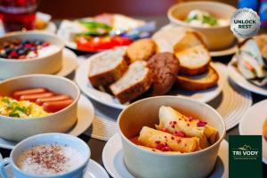 a table topped with bowls of food and plates of food at TRI VODY Demänovská Dolina in Liptovský Mikuláš