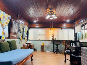 a living room with a bed and a ceiling at โฮมสเตย์ริมน้ำน่าน บ้านอิ๊กขะหลิ๊ก in Nan
