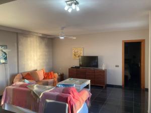 a living room with a couch and a tv at Beach Apartment Marfolin 17 El Cotillo Adults Only in El Cotillo