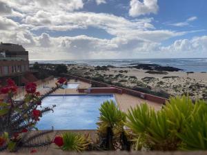 a view of a swimming pool and the beach at Beach Apartment Marfolin 17 El Cotillo Adults Only in El Cotillo