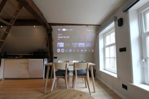 a room with a table and two chairs and a screen at Stay at Gouwzee in Monnickendam