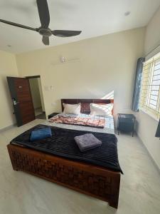 a large bed in a room with a ceiling fan at Drizzle Home - A Cosy Stay in Yercaud