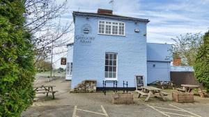 a blue building with picnic tables in front of it at The Gregory Arms in Harlaxton