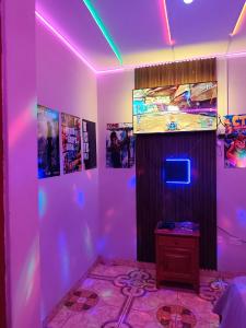 a room with purple lights on the wall and a table at Hotel Prince in Barranca +16 photos