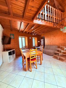 ein Esszimmer mit einem Tisch und einem Sofa in der Unterkunft Maison Chamallow in Chorges