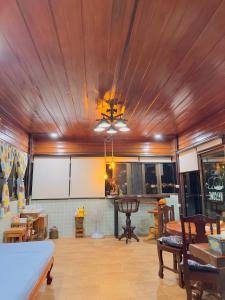 a living room with a wooden ceiling and a table at โฮมสเตย์ริมน้ำน่าน บ้านอิ๊กขะหลิ๊ก in Nan