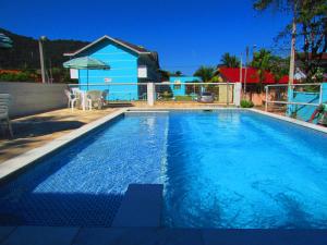 a swimming pool in front of a house at Chalés Céu e Mar Ubatuba in Ubatuba