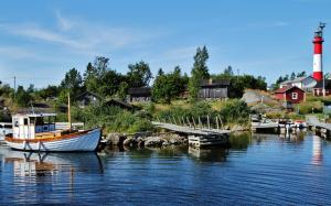 a boat is docked at a dock with a lighthouse at Original Sokos Hotel Kaarle Kokkola in Kokkola