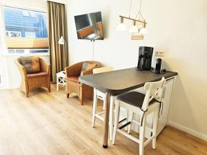 a kitchen and dining room with a table and chairs at Strand Sand Sylt in Westerland