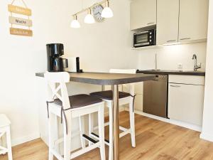 a kitchen with a table and stools in a room at Strand Sand Sylt in Westerland