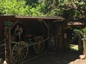 a woman sitting in a wooden cart in a shed at Mantis and Moon Surf Paradise & Adventure Lodge in Hibberdene +5 photos
