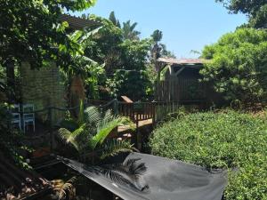 a garden with a fence and some plants at Mantis and Moon Surf Paradise & Adventure Lodge in Hibberdene