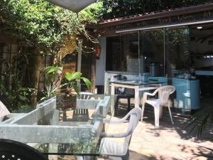 a patio with white chairs and a table and a restaurant at Mantis and Moon Surf Paradise & Adventure Lodge in Hibberdene