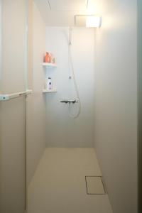 a white bathroom with a shower with a glass door at Sumiyoshi Guesthouse 梦阁 粉浜の宿 in Osaka +68 photos
