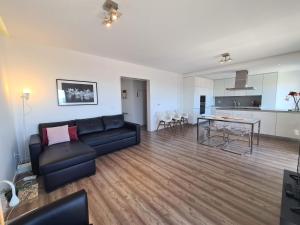 a living room with a couch and a table at Bright by the Beach - by CoH in Cruz Quebrada