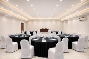 a banquet hall with tables and chairs and a podium at Taaffeite Hotels And Resorts in Lonavala +19 photos