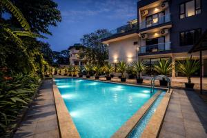 a swimming pool in front of a building at night at Taaffeite Hotels And Resorts in Lonavala