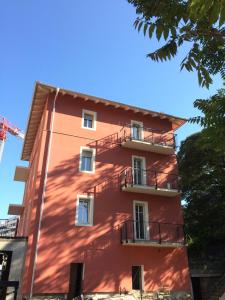 un edificio rojo con balcones en un lateral en Casa Franceschi en Trento