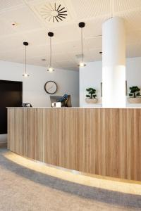an office lobby with a wooden reception desk at Original Sokos Hotel Kaarle Kokkola in Kokkola
