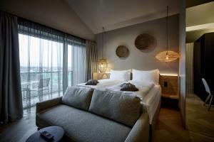 a bedroom with a bed and a couch and a window at Hotel Gerl in Salzburg