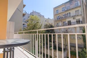 a balcony with a table and a building at BALLET MAISON in the heart of the city in Alexandroupoli