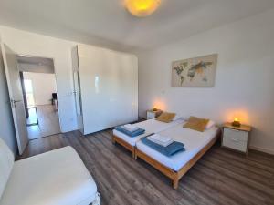 a bedroom with a bed with two towels on it at Bright by the Beach - by CoH in Cruz Quebrada