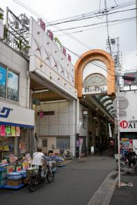 a person riding a bike in front of a store at Sumiyoshi Guesthouse 梦阁 粉浜の宿 in Osaka