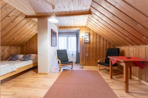 a bedroom with a bed and two chairs and a table at U Stosela- wiejski dom w górach in Biały Dunajec