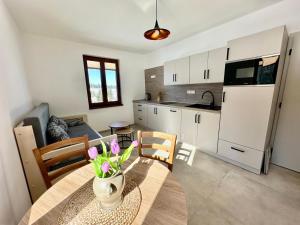 a kitchen and dining room with a table with flowers on it at Pod Lovčí skálou in Modrava +32 photos