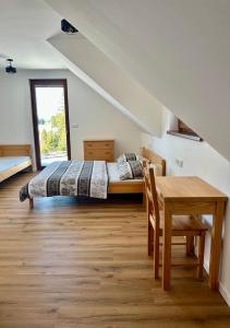 a bedroom with a bed and a table and a window at Pod Lovčí skálou in Modrava