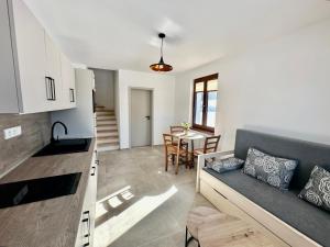 a kitchen and living room with a couch and a table at Pod Lovčí skálou in Modrava