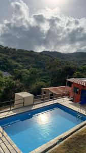 a large blue swimming pool in front of a house at Casa azul Recanto Doce Lar in Gravatá