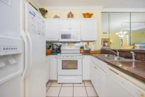 a kitchen with white cabinets and a white stove top oven at Island Royale 404 in Gulf Shores