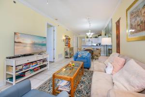 a living room with a couch and a tv at Island Royale 404 in Gulf Shores