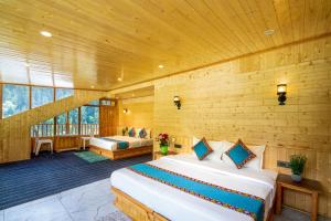 a bedroom with two beds in a room with wooden walls at Khwaab Stays in Shoja