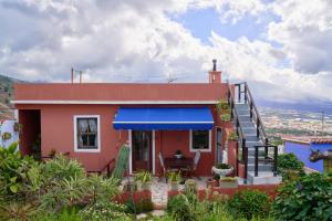 a small red house with a blue awning at Villa Sila in El Paso