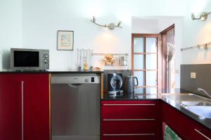 a kitchen with red cabinets and a microwave at Villa Sila in El Paso