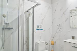 a white bathroom with a shower and a toilet at Villa Sila in El Paso +28 photos