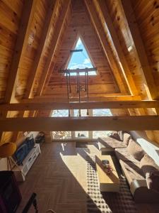 an attic view of a living room with a window at Mountain House Una in Žabljak