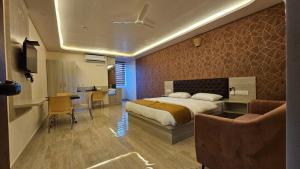 a bedroom with a bed and a table and a desk at New KR Inn in Jadgenhalli