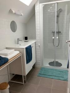 a white bathroom with a shower and a sink at Le Balcon in Frazé