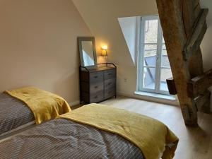 a bedroom with a bed and a dresser with a mirror at Le Balcon in Frazé