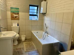 a bathroom with a tub and a toilet and a sink at Godolphin beach house in Cape St Francis +27 photos