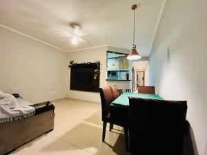 a dining room with a table and a kitchen at Casa Spar do Atlântico com Piscina in Maricá